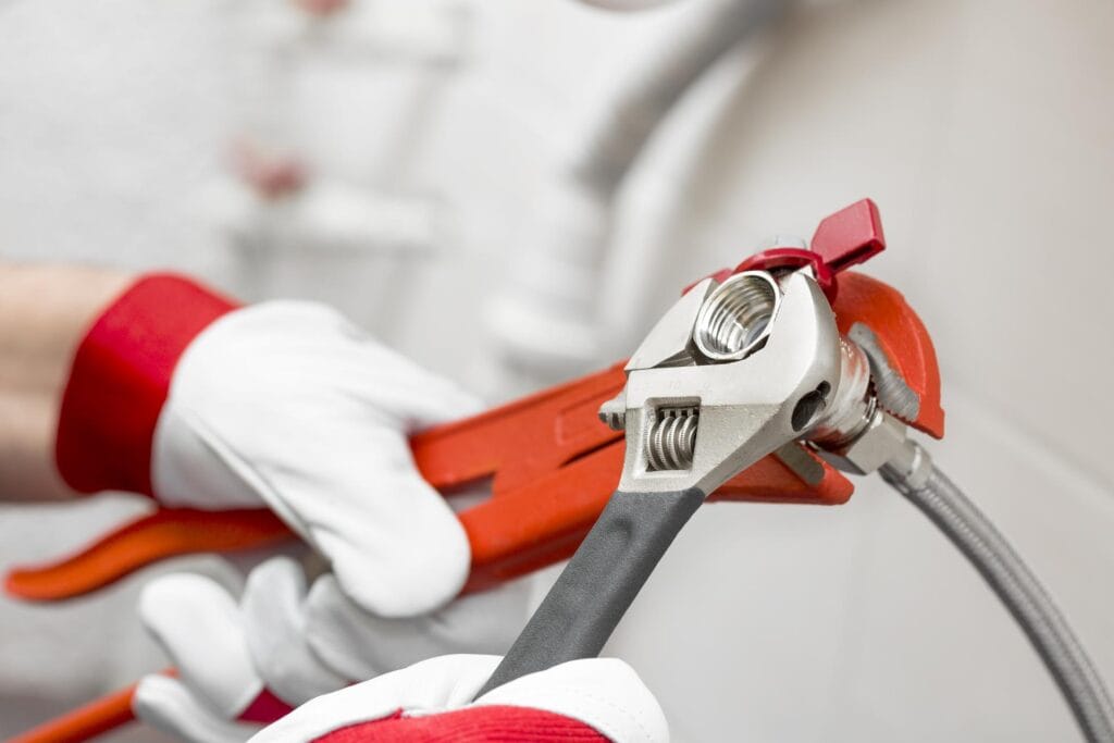 Plumber holding pipe wrenches for an emergency repair in North Fort Myers