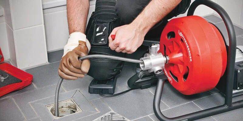 Plumber using a drain-cleaning machine in North Fort Myers