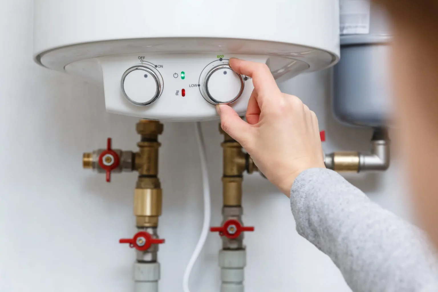 Homeowner adjusting the temperature controls on a water heater in North Fort Myers